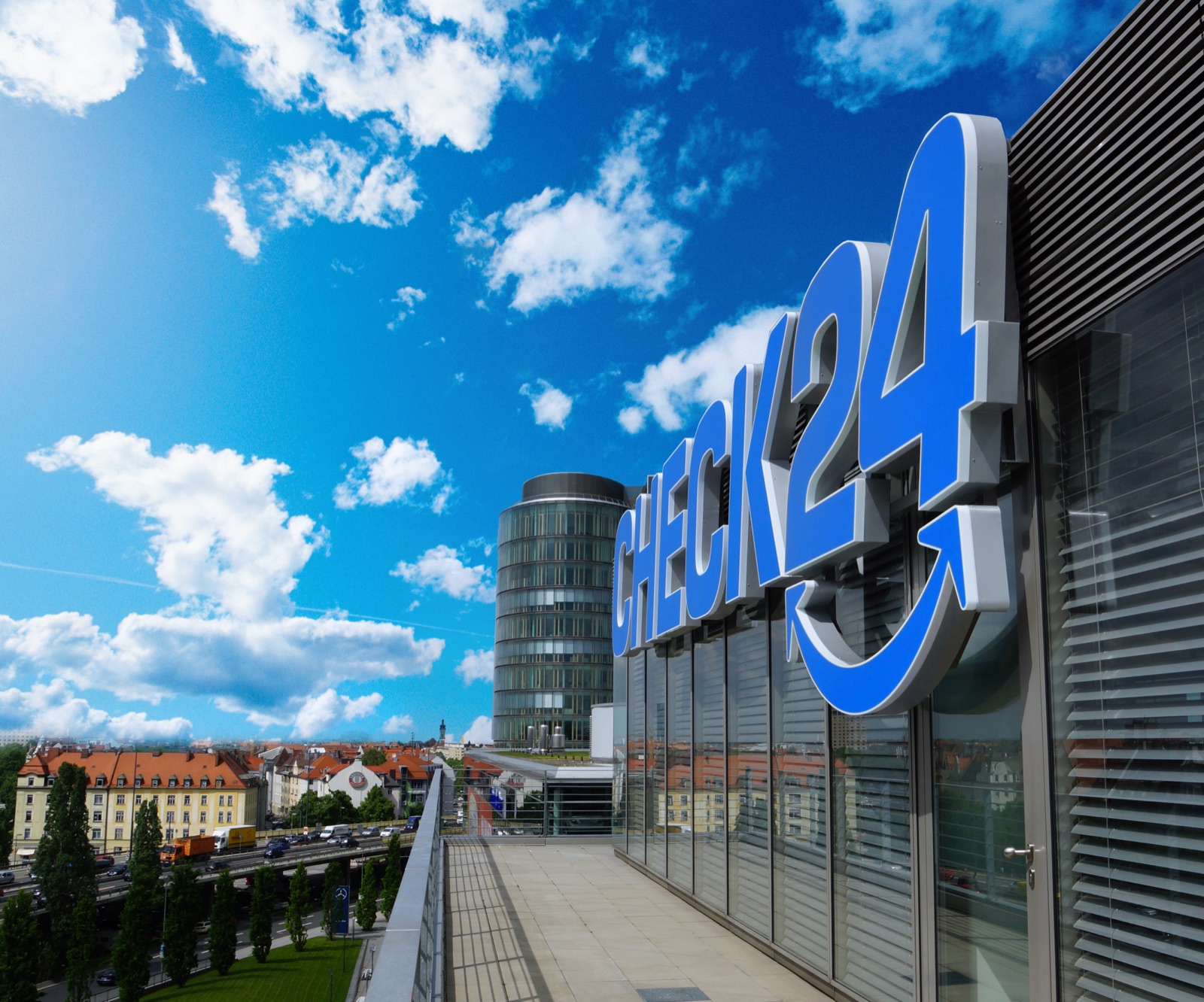 A CHECK24 office building with the bright blue CHECK24 logo above a glass facade.